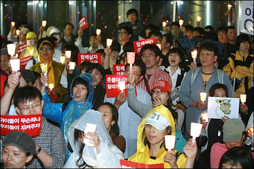 7일 저녁 서울 청계광장에서 비가 내리는 가운데 열린 미국산 쇠고기 전면 수입개방 반대 촛불문화제에서 참가자들이 촛불을 들고 함성을 외치고 있다.