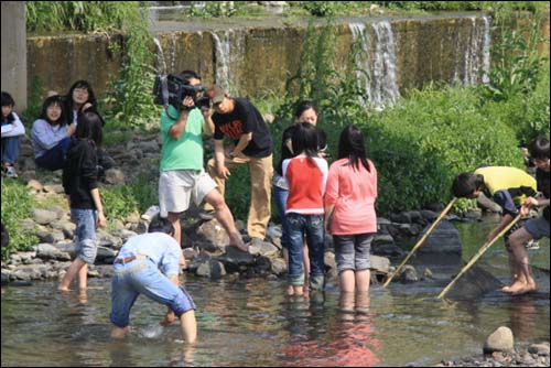 어떤 물고기가 살고 있는 지를 알아보기 위해 물고기를 잡고 있는 강강수월래단 아이들. SBS <물은 생명이다> 팀이 취재를 나왔다. 