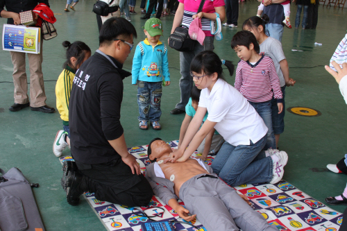 응급구조사 교관이 어린이들에게 심폐소생술방법을 교육시키고 있다.