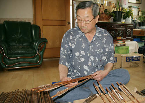  화살을 살펴보고 있는 궁시장 보유자 박호준 선생.