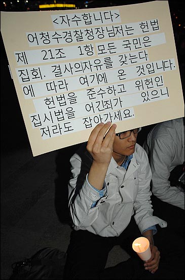 14일 저녁 서울 시청앞 잔디광장에서 열린 "미국산 쇠고기 수입 전면 개방을 반대 촛불문화제"에서 한 참가자가 경찰이 광우병 관련 촛불 집회를 불법으로 규정하고 주최자들을 사법 처리한다는 방침에 항의하고 있다.