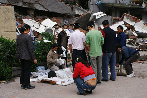 지진으로 매몰된 동료 노동자의 시신을 수습하는 윈펑화학회사 직원들. 