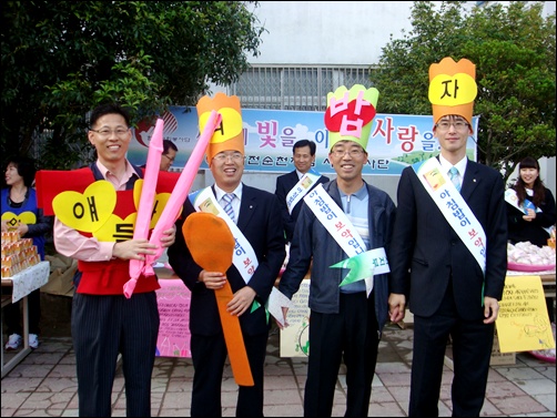 아이들을 즐겁게 해주기 위해 퍼포먼스를 준비하고 있는 한국전력 순천지점 사회봉사대원들과 순천농협중앙회 직원들. 