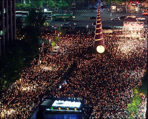  미국산 쇠고기 수입 전면 개방을 반대하는 학생과 시민들이 17일 저녁 서울 청계광장에서 열린 '5.17 미친소, 미친교육, 촛불문화제'에서 정부의 미국산 쇠고기 수입 정책 철회를 촉구하며 촛불을 들고 있다. 