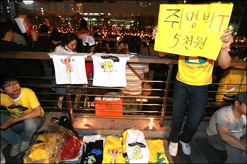 17일 저녁 서울 청계광장에서 광우병위험미국산쇠고기 수입반대 촛불문화제가 열리는 가운데, 이명박 대통령을 풍자한 티셔츠가 행사장 곳곳에서 판매되고 있다.