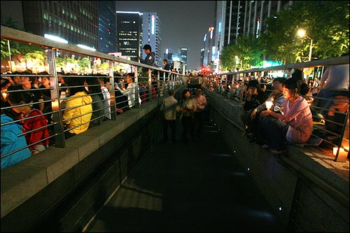 청계천으로 내려가는 통로 주변에 촛불을 든 시민들이 모여 있다.