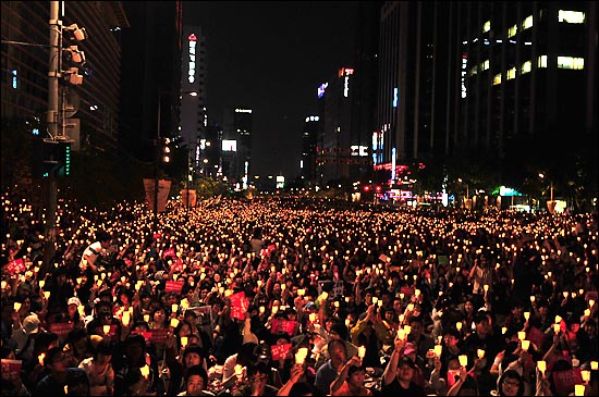  17일 저녁 서울 청계광장에서 열린 '5.17 미친소, 미친교육, 촛불문화제'에서 정부의 미국산 쇠고기 수입 정책 철회를 촉구하며 촛불을 들고 있다. 