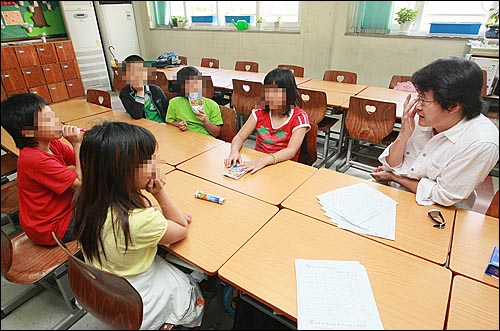  한 초등학교 선생님이 방과후 학생들과 함께 학교생활 및 방과후 생활에 대해 이야기를 나누고 있다.