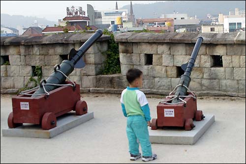 진주성에서 한 어린이가 조선시대 대형총통을 바라보고 있다.