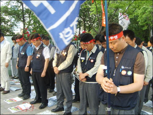 21일 울산시청 앞에서 열린 사회공공성 강화를 위한 결의대회에서 참가자들이 묵념을 하고 있다