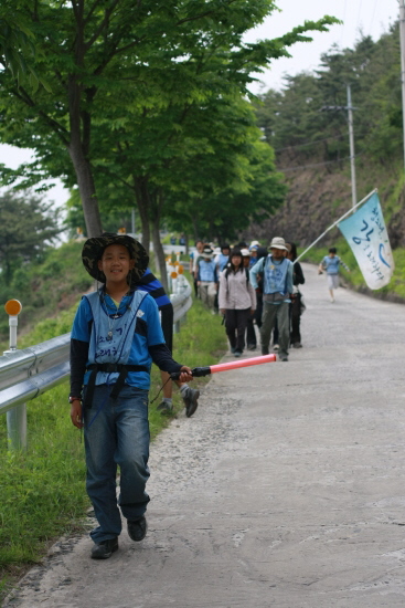 강강수월래단 도보중인 강강수월래단. 맨 앞서 안전봉을 들고 걷는 이가 14세 용훈이.