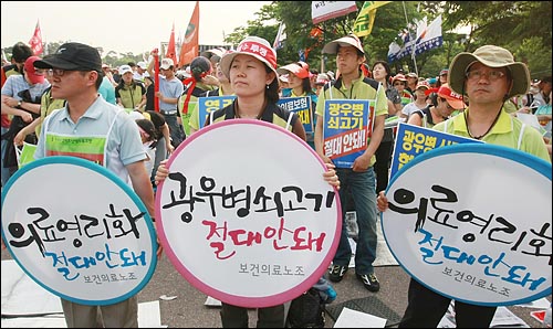 보건의료노동조합원들이 지난 2008년 5월 24일 서울 여의도 여의도 문화마당서 열린 민주노총 총력투쟁 결의대회에서 정부가 공공부문을 민영화하려는 계획의 철회를 요구하며 피켓을 들어보이고 있다.