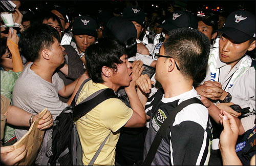미국산 쇠고기 수입에 반대하는 촛불문화제에 참석했던 학생과 시민들이 24일 밤 행사를 마친 뒤 청와대로 행진하려하자 경찰이 이들을 막고 나서 몸싸움을 벌이고 있다.