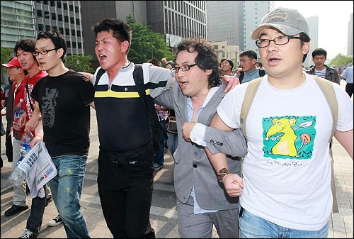 경찰들과 대치 상황을 마친 학생과 시민들이 25일 오전 서울 청계광장에 모여 정부의 미국산 쇠고기 수입 정책 철회를 촉구하며 구호를 외치고 있다. 