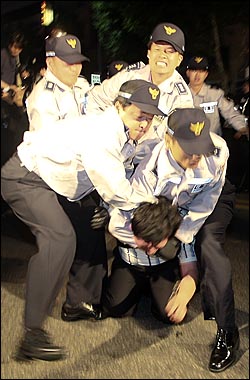 27일 새벽 종로 거리를 점거한 채 미국산 쇠고기 수입 반대 집회를 열고 있던 시민들을 경찰들이 강제 연행하고 있다.
