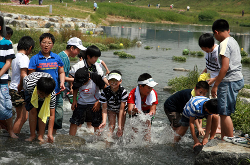 대전천 통수식으로 수량이 늘어나자 아이들이 대전천에서 불장구를 치고 있다.