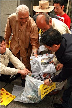 규탄기자회견을 연 뒤, 조중동(조선일보, 중앙일보, 동아일보)을 쓰레기봉투에 넣는 퍼포먼스를 벌이고 있다.