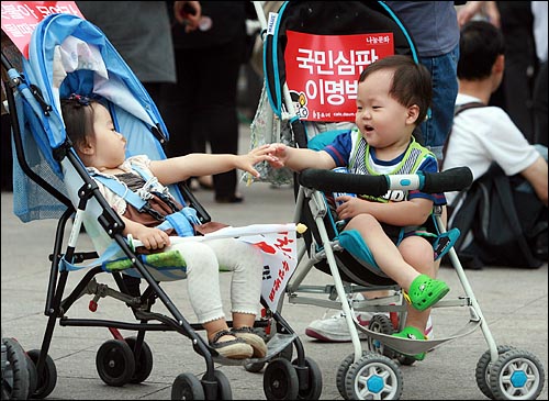 한미 쇠고기협상 장관 고시가 발표된 29일 오후  광우병위험 미국산쇠고기 수입반대 제22차 촛불문화제가 열리는 서울시청앞 광장에서 유모차를 탄 어린이들이 장난을 치고 있다.