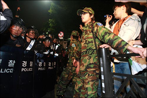  한미 쇠고기 협상 장관 고시 무효를 주장하며 30일 새벽까지 서울 세종로 네거리 도로에거 농성을 벌이던 시민, 학생들을 경찰이 강제해산시키자 예비군복을 입은 시민들이 경찰 앞을 가로막고 있다.