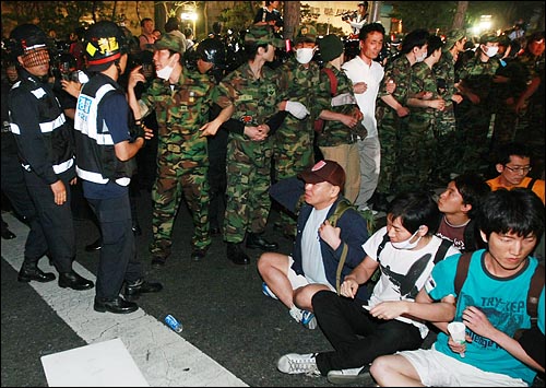 30일 새벽 서울 세종로 네거리 도로에서 연좌농성을 벌이던 시민과 학생들을 경찰들이 강제해산시킬 준비를 하자 예비군복을 입은 시민들이 경찰 앞을 가로막고 있다.
