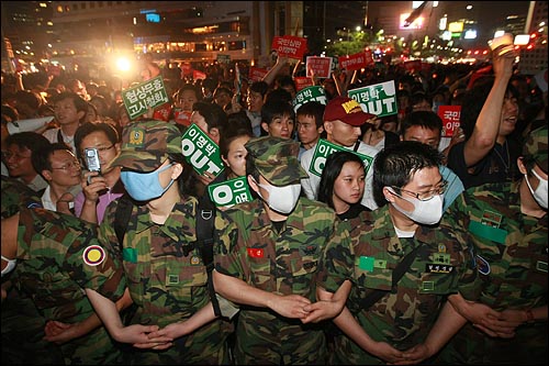 2008년 5월 30일 저녁 미국산 쇠고기 수입 전면 개방을 반대하는 학생과 예비군복을 입은 시민들이 서울 시청광장에서 열린 촛불문화제를 마친뒤 덕수궁 앞에서 경찰과 대치를 벌이며 구호를 외치고 있다.
