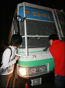  30일 밤 서울 시청광장에서 열린 촛불문화제를 마친뒤 시가행진하는 시민들과 경찰이 대치를 벌이던 중 덕수궁 앞에서 전경버스에 시민이 치이는 사고가 나자 시민들이 가해 전경버스 안을 보고 있다.