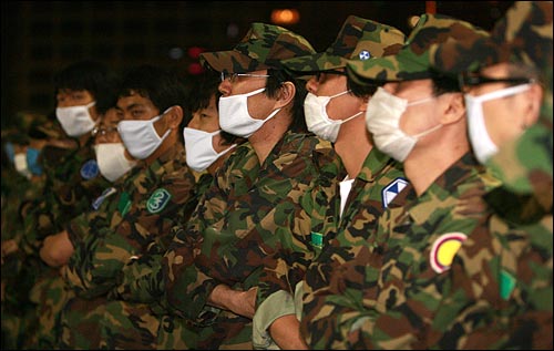 광우병위험 미국산쇠고기 수입에 반대하는 밤샘시위가 벌어지는 31일 새벽 서울시청앞 도로에서 예비군복을 입은 수십명이 스크럼을 짜고 경찰의 진압에 대비하고 있다.