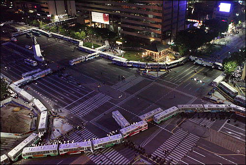 31일 밤 서울 시청 앞 광장에서 열린 미국산 쇠고기 수입반대 촛불문화제에 참가한 시민들이 거리행진을 시작한 가운데 광화문 사거리는 전경차와 경찰 병력으로 원천 봉쇄돼있다.