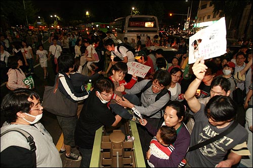 31일 밤 서울시청앞 광장에서 열린 광우병위험 미국산쇠고기 수입반대 및 재협상 촉구 24차 촛불문화제를 마친 시민, 학생 수천명이 사직공원을 지나 청와대를 향해 행진을 벌이고 있다. 어린 아이들과 함께 온 부모들이 아이를 중앙분리대를 넘겨 옮기고 있다.