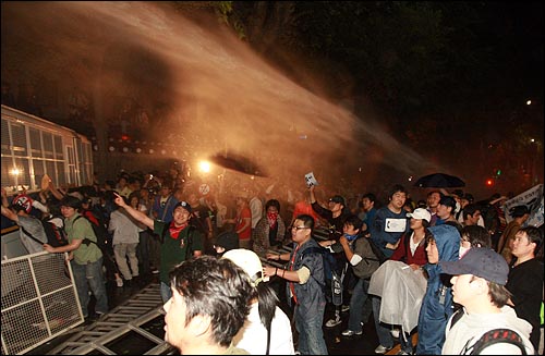 1일 새벽 서울 효자동 청와대 입구에서 경찰이 광우병위험 미국산쇠고기 수입반대 및 재협상을 요구하며 '이명박 나와라'를 외치는 시민,학생들에게 살수차(물대포)로 물을 뿌리고 있다.