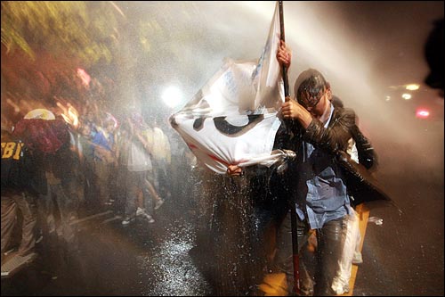 1일 새벽 서울 효자동 청와대 입구에서 경찰이 광우병위험 미국산쇠고기 수입반대 및 재협상을 요구하며 '이명박 나와라'를 외치는 시민,학생들에게 살수차(물대포)로 물을 뿌리고 있다.