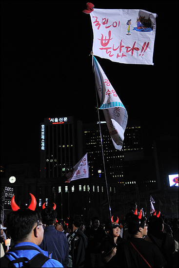 8시 39분. 서울시청 앞 광장의 시위대. 드라마 제목을 패러디한 듯한 "국민이 뿔났다"는 구호가 많이 보인다. 이에 맞춰 붉은악마 야광뿔도 재등장했다.