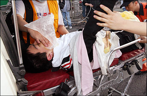 지난 1일 아침 미국산 쇠고기 수입에 반대하며 서울 삼청동에서 청와대 방향으로 진입하려던 집회 참가자가 경찰 진압과정에서 다쳐 응급차에 실려가고 있다. 