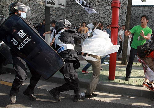 1일 아침 안국동 사거리에서 경찰이 시위대를 해산시키면서 도망치는 한 시민의 머리를 몽둥이로 내려치고 있다.