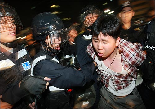 광우병위험 미국산쇠고기 수입반대 및 재협상을 요구하는 시민이 2일 새벽 서울 세종로 사거리에서 재협상을 요구하며 시위를 벌이다가 경찰에게 연행되고 있다.