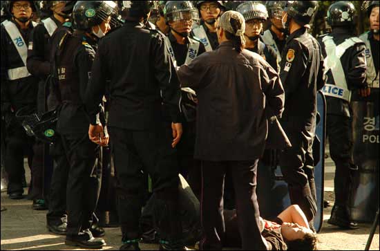 종각 앞에서 시위대에 참가한 한 학생이 전경의 방패에 머리를 맞아 쓰러져 있다.