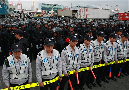 농림수산식품부가 미국산 쇠고기 수입위생조건 관보 게재를 유보한 가운데 경찰들이 2일 오후 부산 감만부두 앞에서 열린 광우병 미국산 쇠고기 운송저지투쟁 촛불문화제에 배치되어 있다.