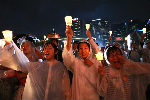  2일 저녁 서울시청앞 광장에서 폭우가 쏟아지는 가운데 열린 광우병위험 미국산 쇠고기 수입반대 및 재협상을 촉구하는 26차 촛불문화제에서 학생들이 촛불을 들고 함성을 외치고 있다.