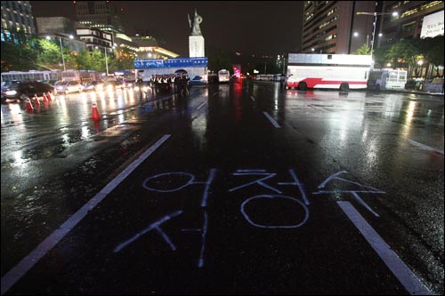 2일 저녁 폭우가 쏟아지는 가운데 서울시청앞 광장에서 광우병위험 미국산쇠고기 수입반대 및 재협상 촉구 26차 촛불문화제가 진행되자 경찰이 세종로 네거리에 경찰버스로 바리케이트를 설치하고 청와대로 향하는 길을 봉쇄했다. 도로 바닥에는 경찰의 과잉진압에 항의하며 시위대가 어청수 경찰청장의 이름을 적어 놓았다.