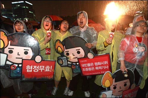 2일 저녁 폭우가 쏟아지는 가운데 서울시청앞 광장에서 열린 광우병위험 미국산쇠고기 수입반대 및 재협상 촉구 26차 촛불문화제에서 참가자들이 어깨동무를 하고 노래를 부르고 있다.