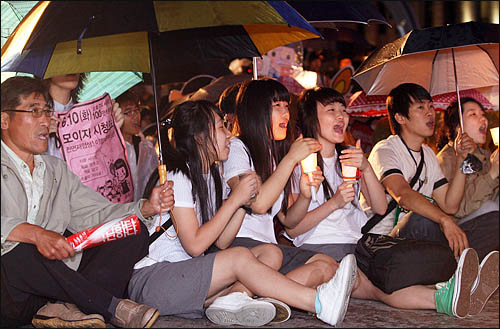 촛불을 들고 거리행진을 마친 집회 참가자들이 3일 밤 서울시청 앞 광장에 다시 모여 '한미 쇠고기 전면 재협상'을 요구하며 함성을 지르고 있다.