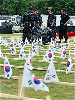 미국산 쇠고기 수입 반대 72시간 릴레이 촛불문화제를 개최하려던 서울시청 앞 광장에 5일 오후 북파공작원들이 북파공작 특수임무 전사자 추모제를 위해 나무로 만든 모형 신위와 태극기를 세우고 있다.