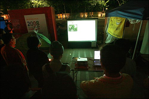 광우병국민대책회의가 '72시간 릴레이 농성'에 돌입한 가운데 6일 새벽 서울시청앞 광장에서 참여연대가 스크린에 오마이뉴스 생중계를 상영하자, 시민들이 모여 72시간 릴레이 집회 생중계를 지켜보고 있다.
