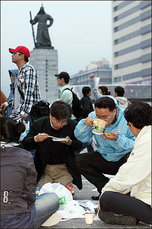미국산 쇠고기 수입에 반대하며 서울 세종로 사거리에서 밤새 농성을 벌인 시민들이 6일 아침 컵라면으로 허기를 달래고 있다.