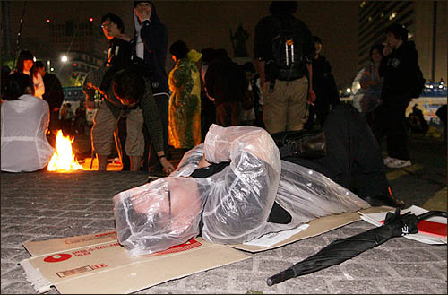 미국산 쇠고기 수입에 반대하며 서울 세종로 사거리에서 밤새 농성을 벌인 시민들이 바닥에 종이 박스를 깔고 6일 새벽 새날을 맞이하고 있다.