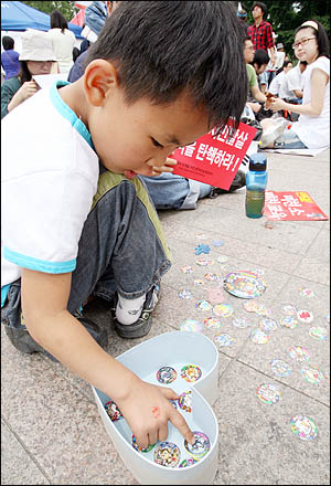 6일 아침 아빠 손을 붙잡고 경기도 오산에서 올라온 7살 소년. 72시간 릴레이 농성이 열리고 있는 서울광장엔 또래 아이들도 많지만 아직은 쑥스러워 딱지치기에 푹 빠져있다.