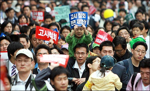  미국산 쇠고기 전명수입개방 반대 72시간 릴레이 농성 둘째일인 6일 오후 서울 대학로에서 집회를 마친 시민, 학생들이 촛불문화제가 열리는 서울시청앞 광장을 향해 행진을 벌이는 가운데 한 어린이가 아빠 무등을 타고 피켓을 들고 있다.