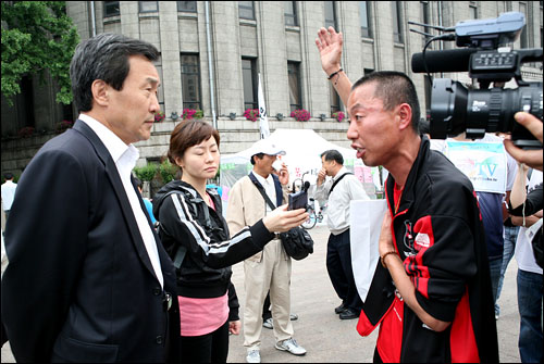  미국 쇠고기 수입반대 72시간 연속 촛불시위 3일째인 7일 오전 서울 시청 앞 광장을 찾은 손학규 민주당 대표 시민들의 요구를 듣고 있다. 이 시민은 "정치권은 정치권 대로 국회에서 미국 쇠고기 해법을 열심히 찾아야 한다"고 강력 요구했다.