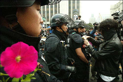 미국산쇠고기 수입 전면개방 반대 72시간 릴레이 농성 나흘째인 8일 새벽 서울 세종로네거리에서 밤을 새워 격렬한 시위가 벌어진 가운데 한 시민이 진압 경찰의 가슴에 꽃을 달아주고 있다.