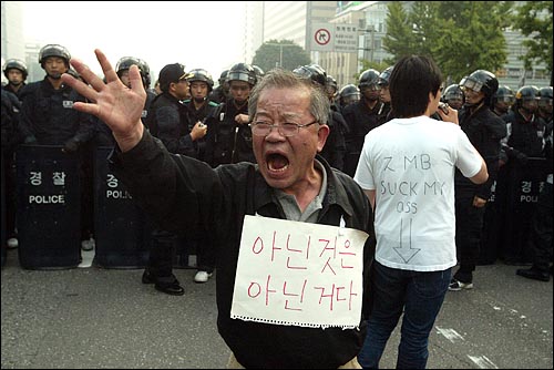미국산쇠고기 수입 전면개방 반대 72시간 릴레이 농성 나흘째인 8일 새벽 서울 세종로네거리에서 밤을 새워 격렬한 시위가 벌어진 가운데 경찰이 시민들을 강제해산시키기 위해 작전에 나서자 한 할아버지가 경찰앞에 나서 이명박 정부를 규탄하고 있다.